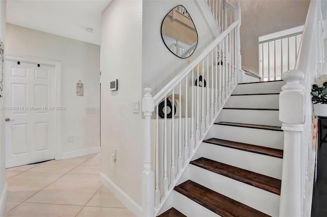 stairway with light tile patterned floors