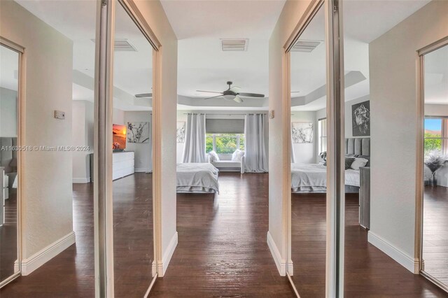 hallway featuring dark hardwood / wood-style floors and a tray ceiling