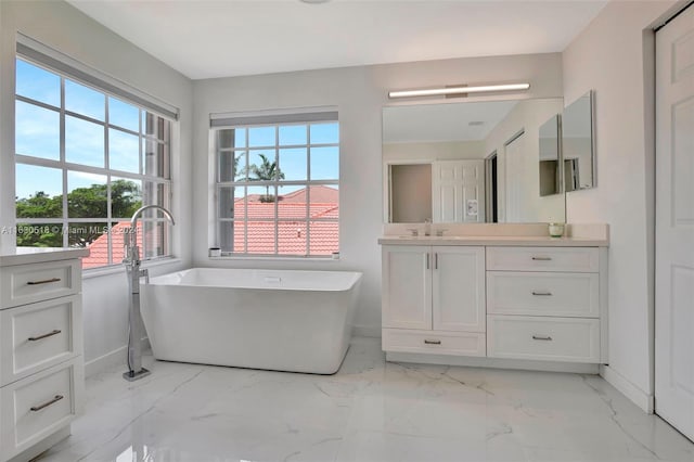 bathroom with tile patterned flooring, a tub, and vanity