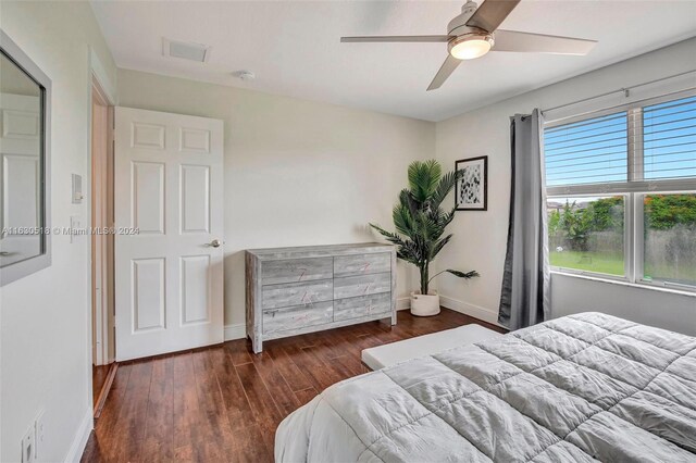 bedroom with dark hardwood / wood-style flooring and ceiling fan