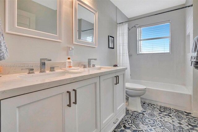 full bathroom with tile patterned floors, dual bowl vanity, toilet, and shower / bath combination with curtain