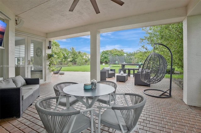 view of patio with ceiling fan, an outdoor living space, and a trampoline