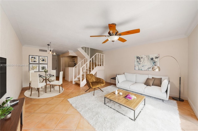 tiled living room with ceiling fan and crown molding