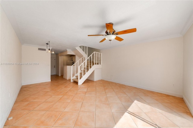 tiled empty room featuring ceiling fan and crown molding