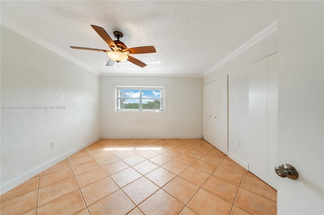 unfurnished room featuring ceiling fan, crown molding, and light tile patterned flooring