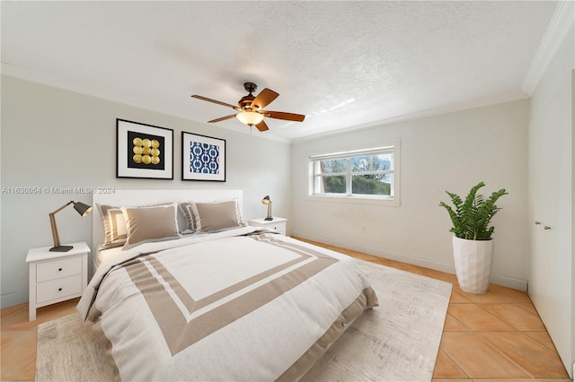 bedroom with a textured ceiling, ceiling fan, crown molding, and light tile patterned floors