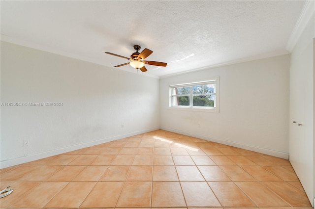 spare room featuring ceiling fan, a textured ceiling, light tile patterned floors, and crown molding