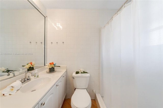 bathroom featuring walk in shower, vanity, tile patterned floors, toilet, and tile walls