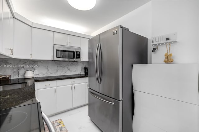 kitchen featuring white cabinetry, tasteful backsplash, light tile patterned floors, stainless steel appliances, and sink