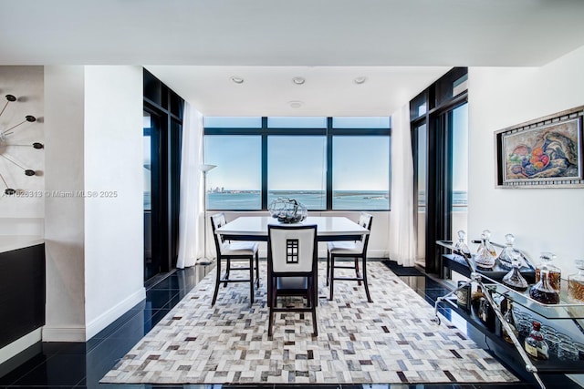 dining area featuring tile patterned flooring and a water view