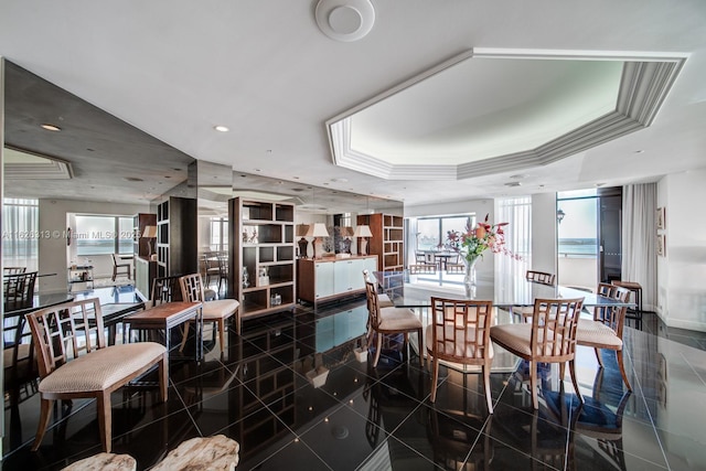 dining area featuring ornamental molding and a raised ceiling