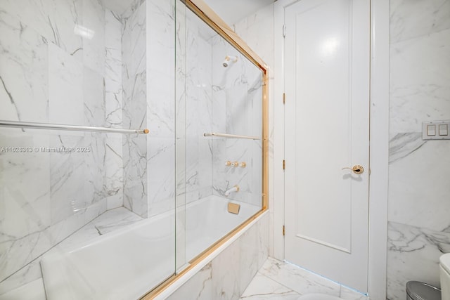 bathroom featuring combined bath / shower with glass door and toilet