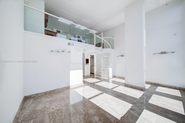 unfurnished room featuring a towering ceiling