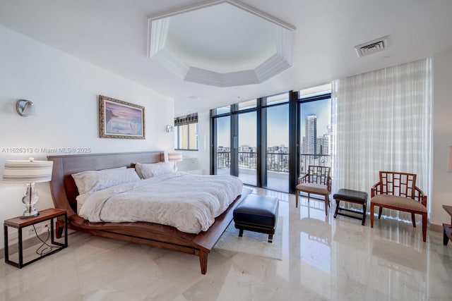 bedroom featuring access to exterior, a wall of windows, ornamental molding, and a raised ceiling