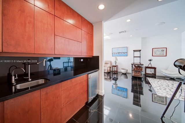 kitchen featuring dark tile patterned floors, sink, and wine cooler