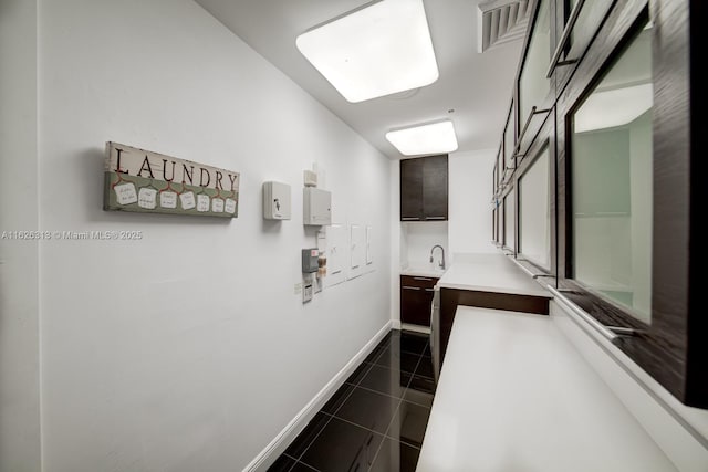 hall with dark tile patterned floors and sink