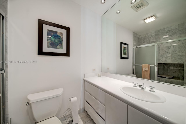 bathroom with an enclosed shower, vanity, tile patterned flooring, and toilet