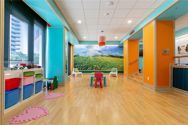 rec room featuring hardwood / wood-style flooring and a paneled ceiling