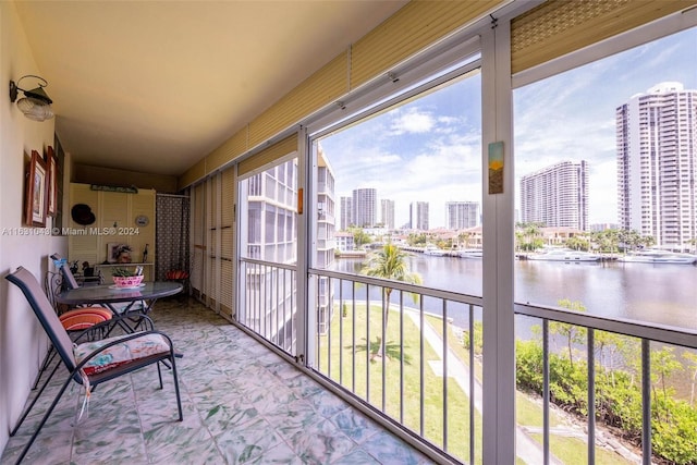 sunroom featuring a water view