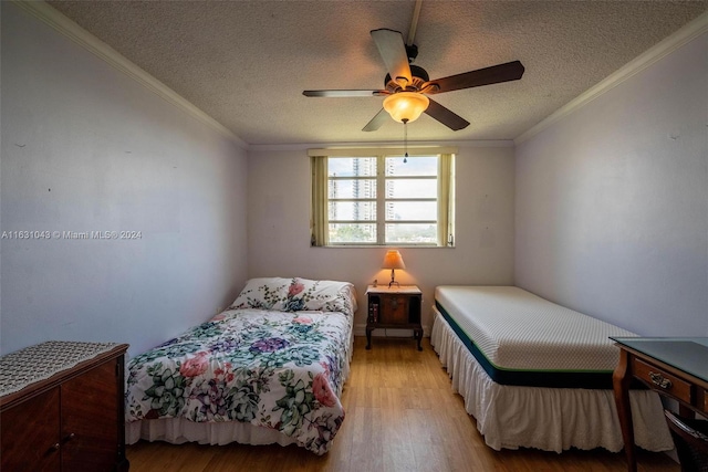 bedroom with crown molding, a textured ceiling, light hardwood / wood-style flooring, and ceiling fan