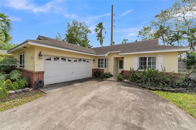 single story home with a garage, brick siding, concrete driveway, and stucco siding