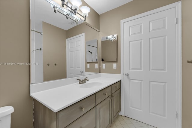 bathroom featuring tile patterned flooring, toilet, and vanity