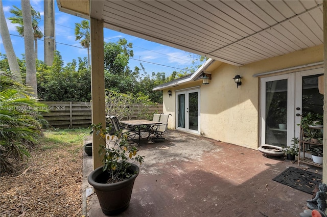 view of patio / terrace featuring outdoor dining space, french doors, and fence