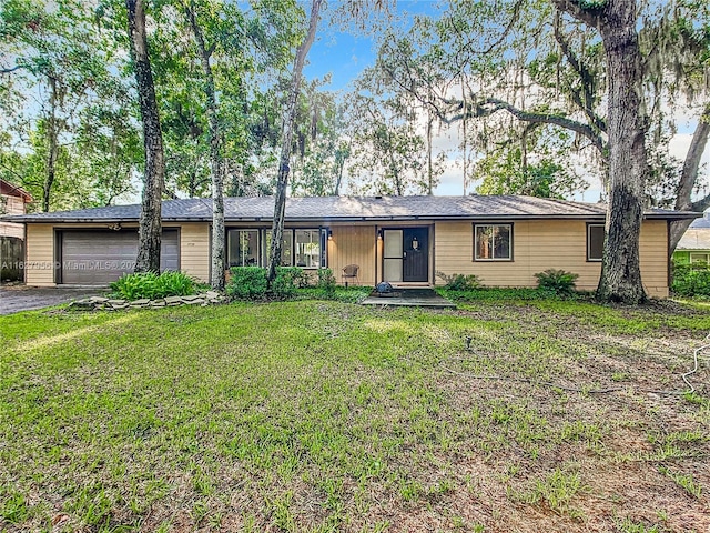 ranch-style home with a garage and a front yard