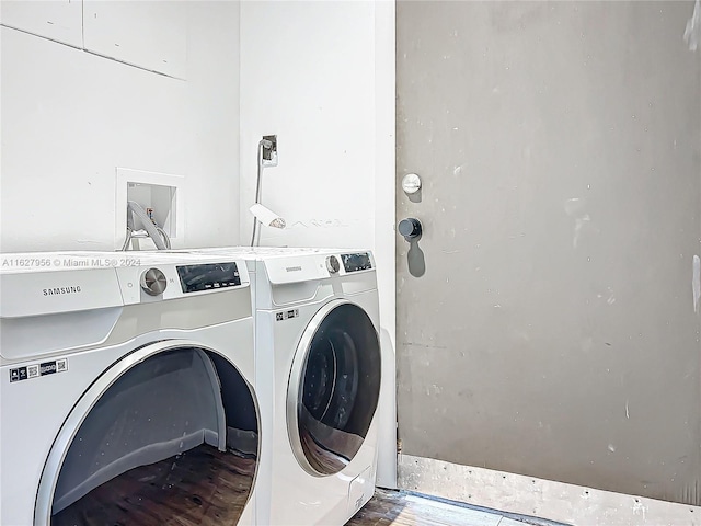 washroom with wood-type flooring and independent washer and dryer