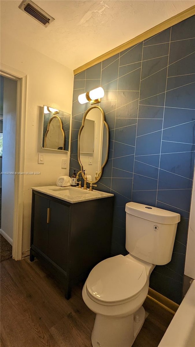 bathroom with vanity, tile walls, hardwood / wood-style flooring, and toilet