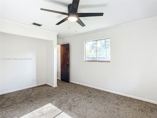 carpeted spare room with ceiling fan and ornamental molding