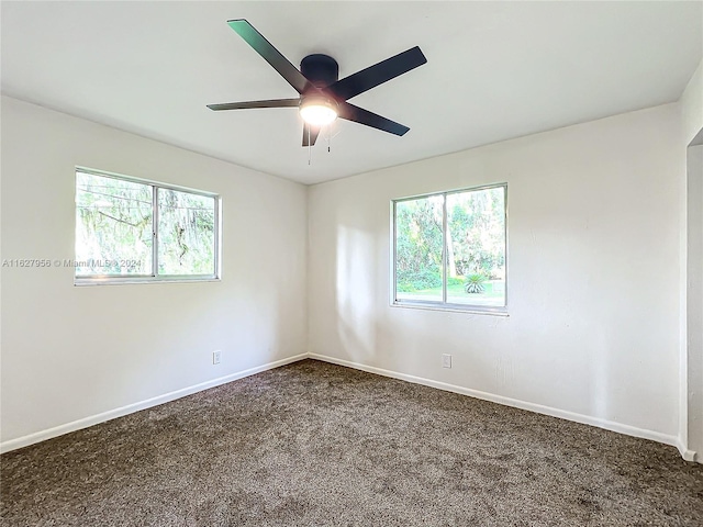 carpeted empty room with a healthy amount of sunlight and ceiling fan