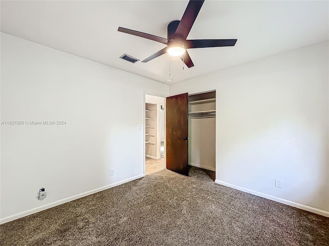 unfurnished bedroom with ceiling fan, carpet flooring, and a closet