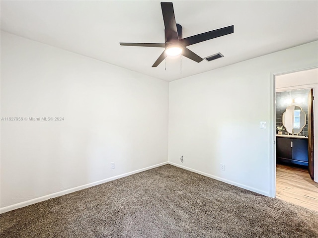 carpeted spare room with ceiling fan