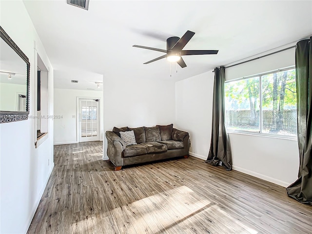 living room featuring light hardwood / wood-style flooring and ceiling fan