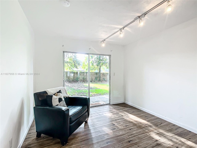 living area with hardwood / wood-style flooring and rail lighting