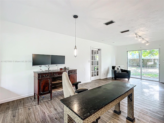 dining area with track lighting and light wood-type flooring