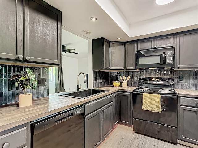 kitchen with light hardwood / wood-style floors, black appliances, ceiling fan, and backsplash