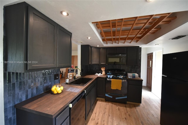 kitchen featuring light hardwood / wood-style flooring, black appliances, wood counters, sink, and decorative backsplash