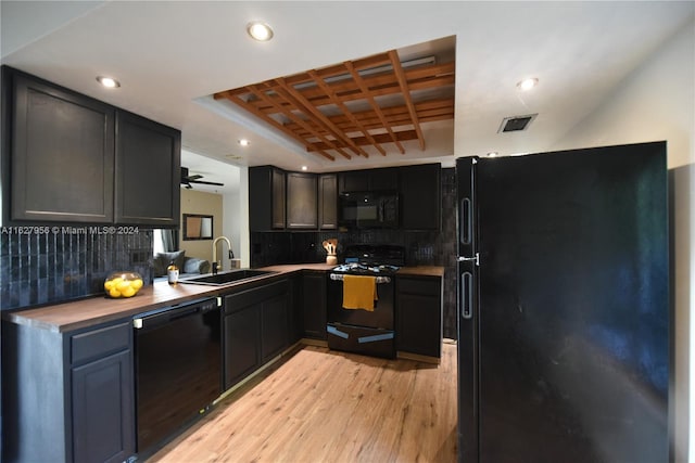 kitchen featuring decorative backsplash, black appliances, coffered ceiling, and sink