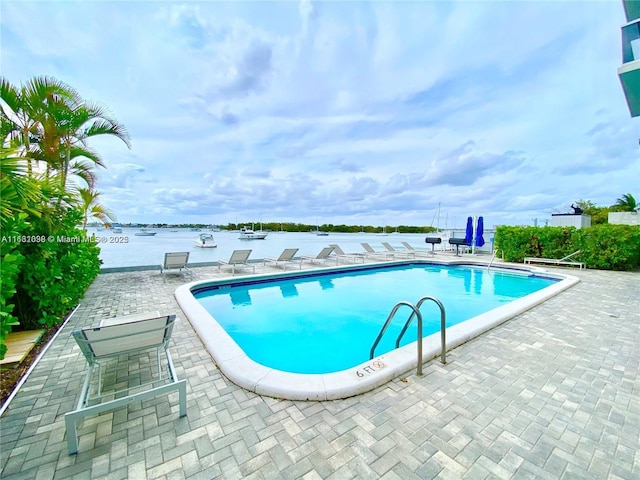 community pool featuring a patio and a water view