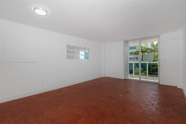 spare room featuring a healthy amount of sunlight and baseboards