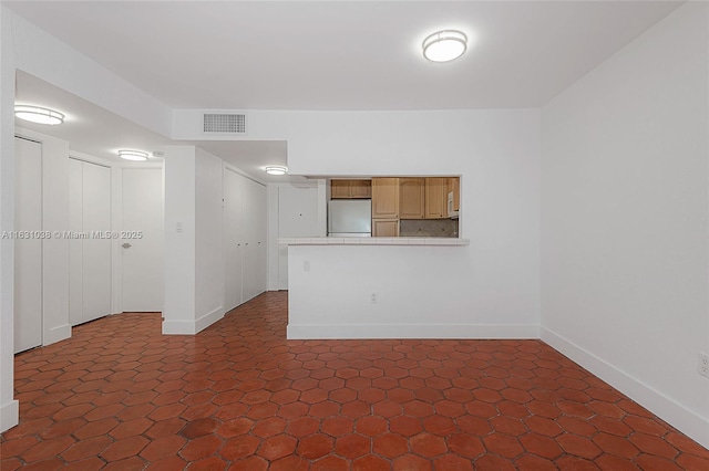 unfurnished room featuring visible vents and baseboards