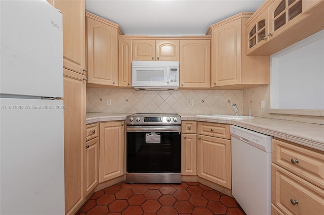 kitchen featuring tile countertops, sink, white appliances, and light brown cabinets