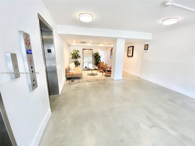 hallway featuring finished concrete flooring and baseboards