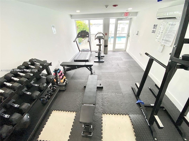 gym with baseboards and a wall mounted AC