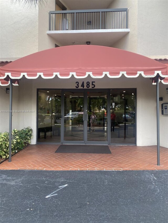 doorway to property with a balcony and stucco siding