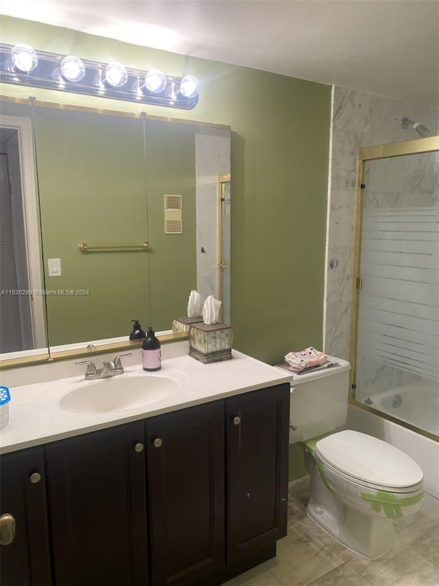 full bathroom featuring tile patterned floors, vanity, shower / bath combination with glass door, and toilet