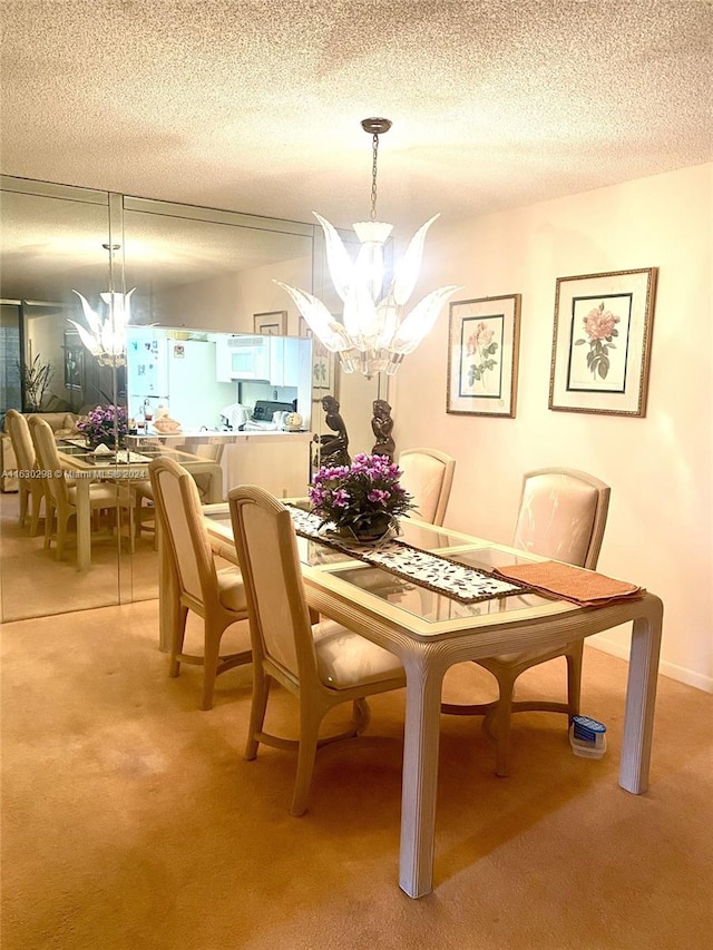 carpeted dining area with a chandelier and a textured ceiling