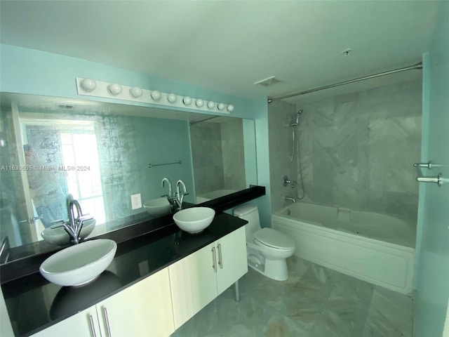 full bathroom featuring tiled shower / bath, toilet, tile patterned floors, and double sink vanity